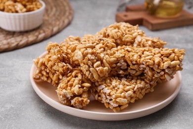 Photo of Plate with puffed rice bars (kozinaki) on grey table, space for text