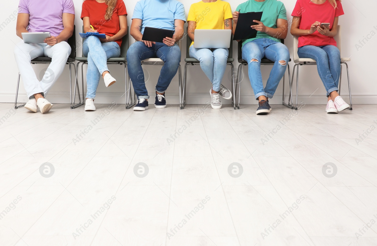 Photo of Group of young people waiting for job interview on chairs