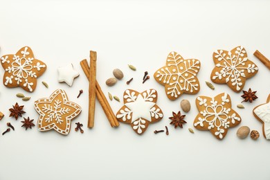 Tasty Christmas cookies with icing and spices on white background, flat lay