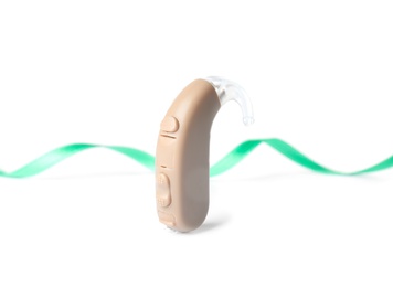 Photo of Hearing aid and ribbon on white background