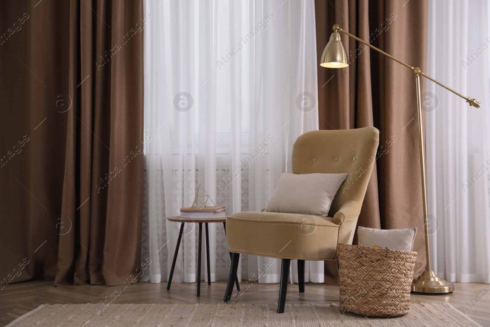 Photo of Comfortable armchair and lamp near window indoors. Interior design