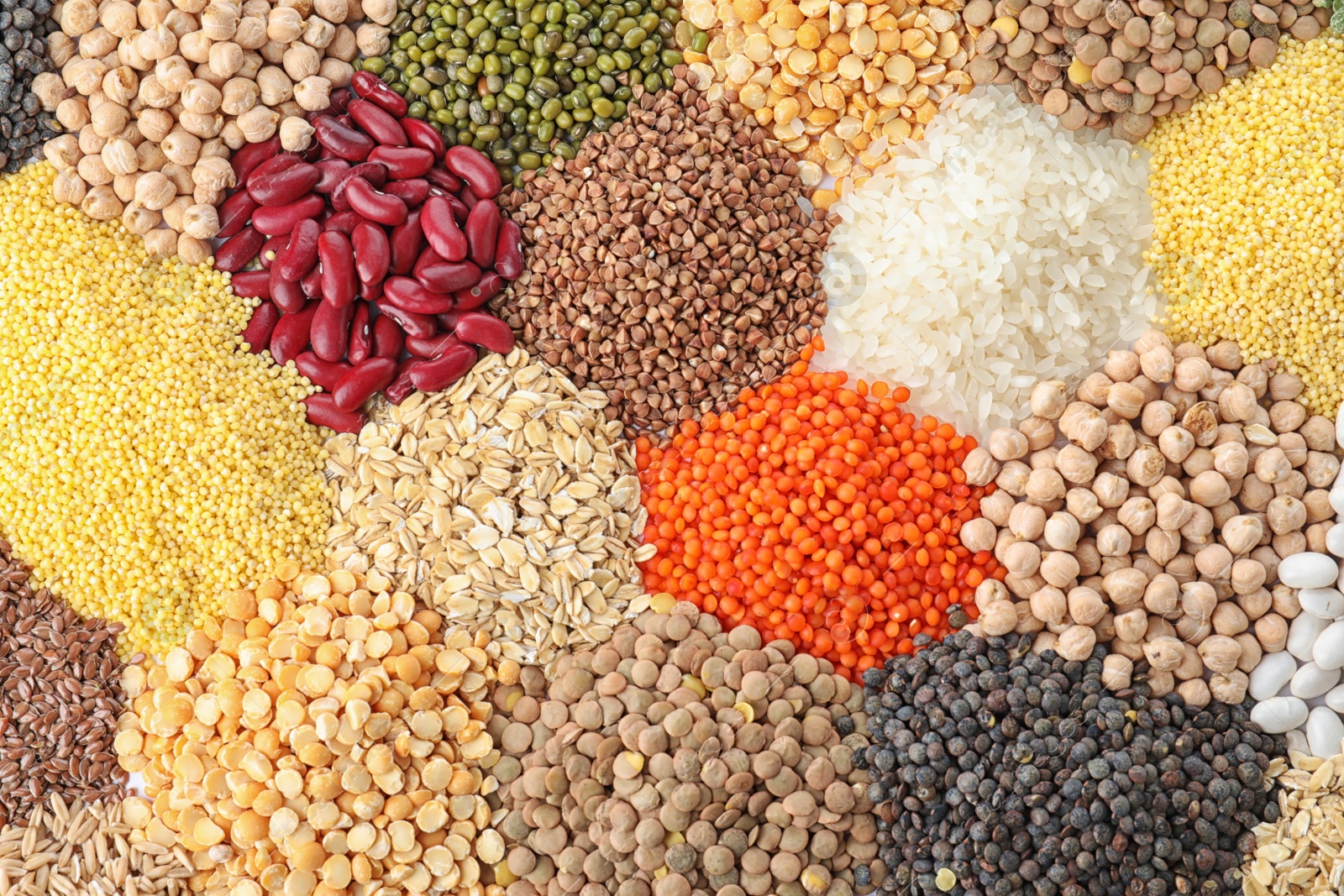 Photo of Different types of legumes and cereals as background, top view. Organic grains