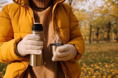 Photo of Woman with thermos outdoors, closeup. Space for text