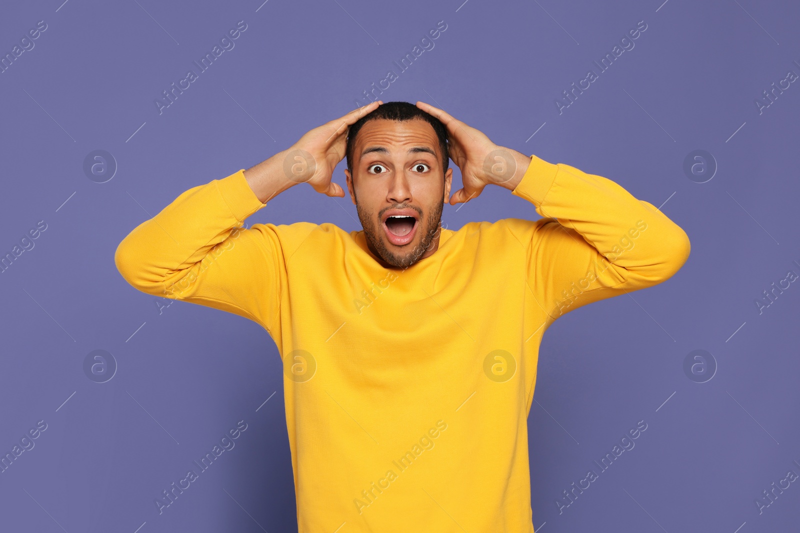 Photo of Portrait of emotional African American man on purple background