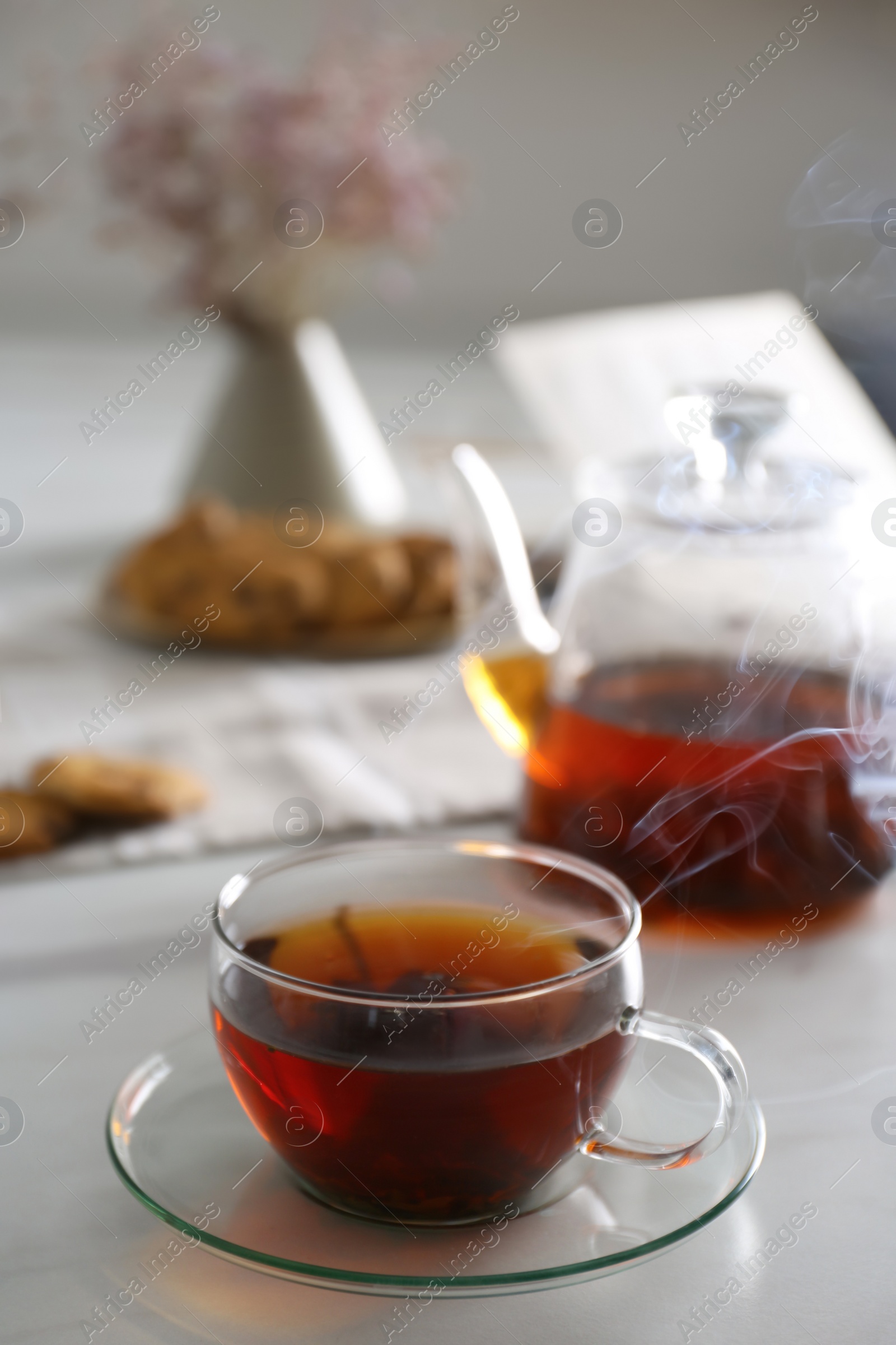 Photo of Glass cup of hot tea served for breakfast on white table