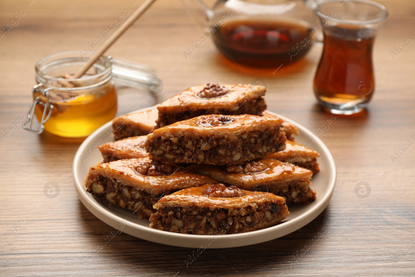 Photo of Delicious sweet baklava with walnuts on wooden table