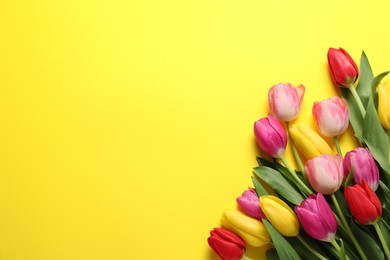 Photo of Beautiful colorful tulip flowers on yellow background, flat lay. Space for text