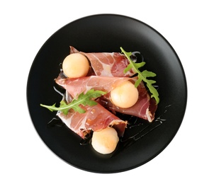 Plate with melon balls and prosciutto on white background, top view