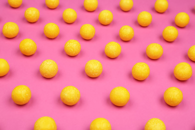 Many delicious lemon drops on pink background