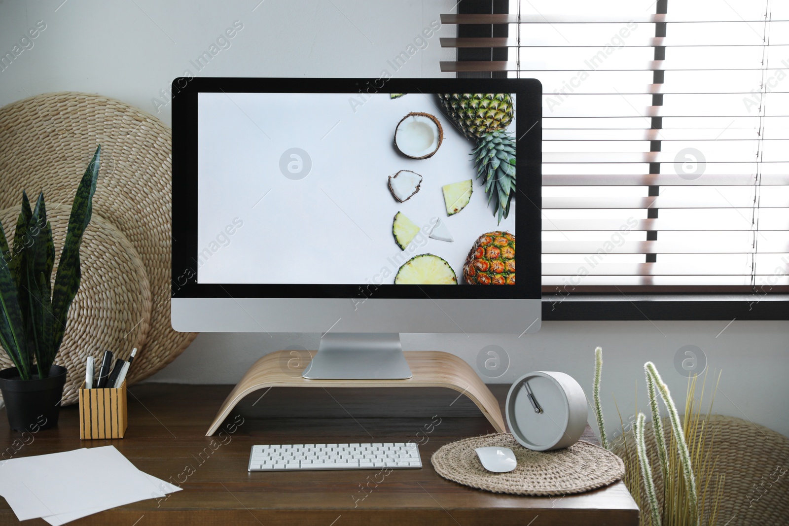 Photo of Comfortable workplace near window with horizontal blinds in room