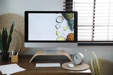 Comfortable workplace near window with horizontal blinds in room