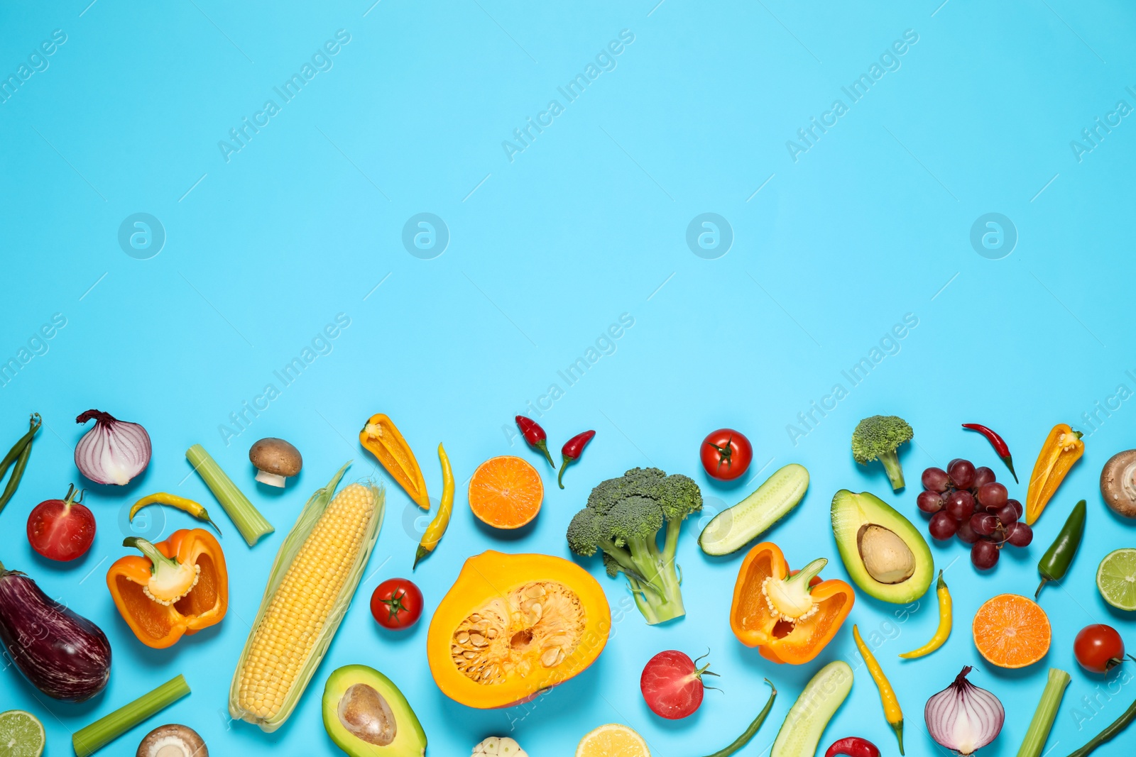 Photo of Flat lay composition with fresh organic fruits and vegetables on light blue background. Space for text