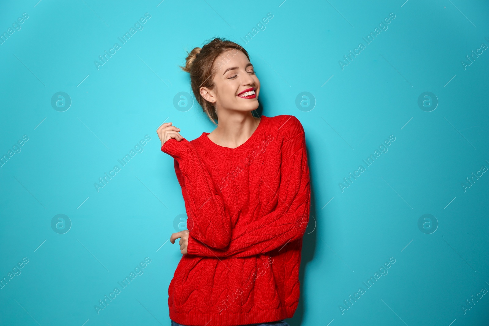 Photo of Beautiful young woman in warm sweater on color background