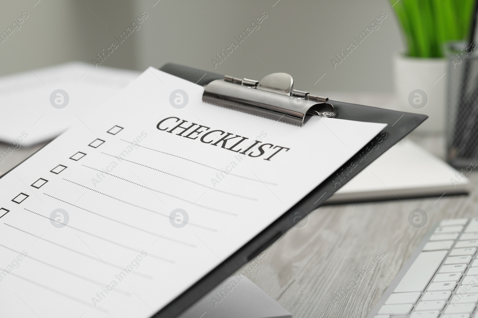 Photo of Clipboard with inscription Checklist indoors, closeup view