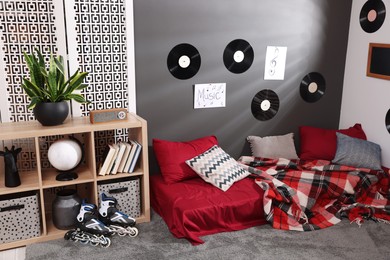 Stylish teenager's room with bed, wooden rack and vinyl records on wall. Interior design