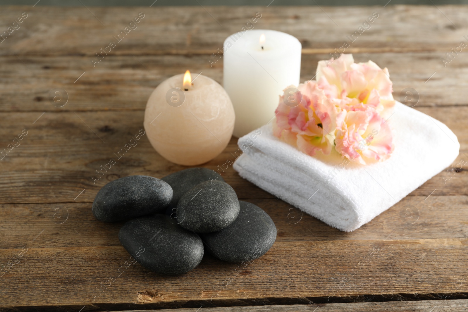 Photo of Composition with spa stones on wooden table