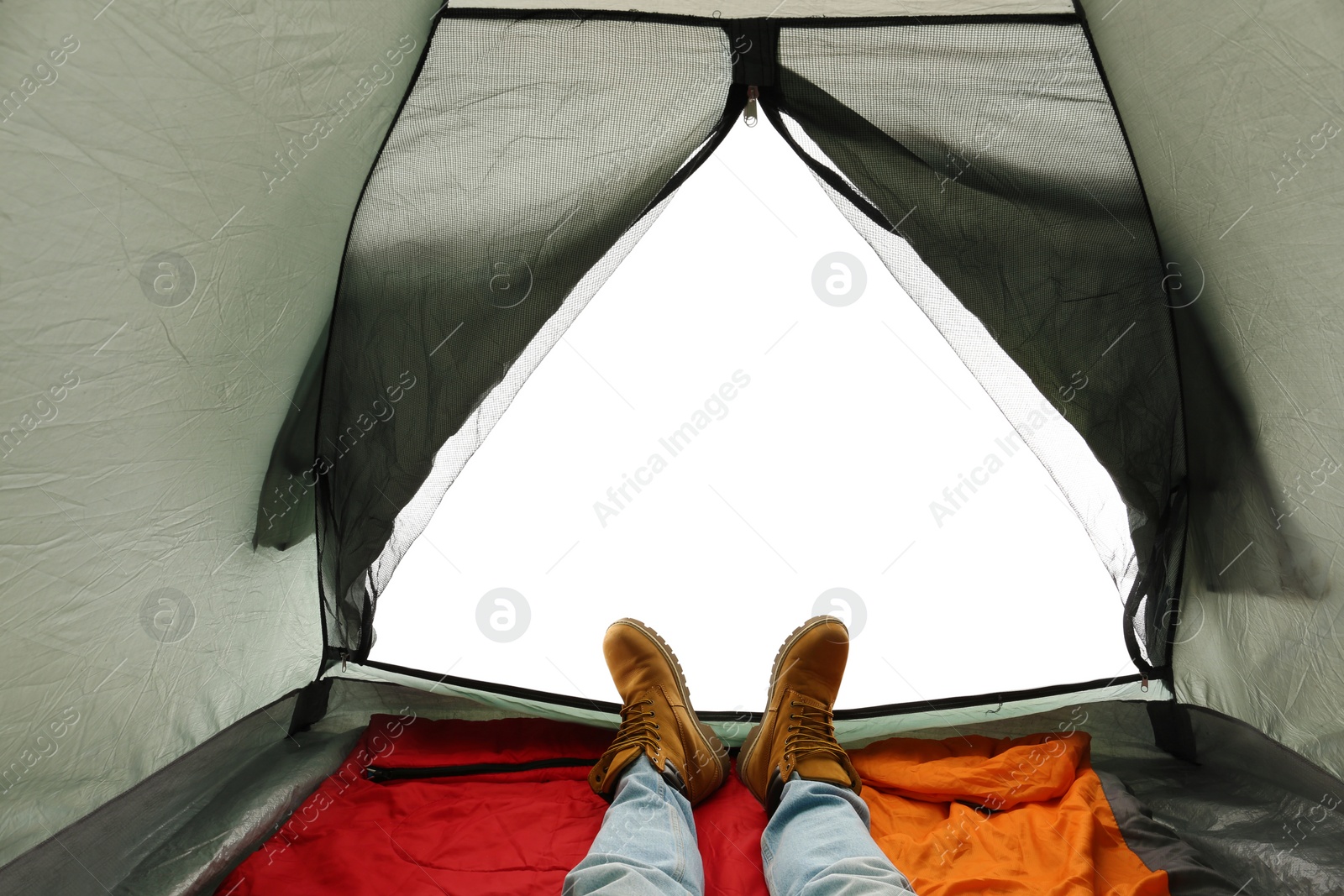 Photo of Closeup of man in camping tent on white background, view from inside