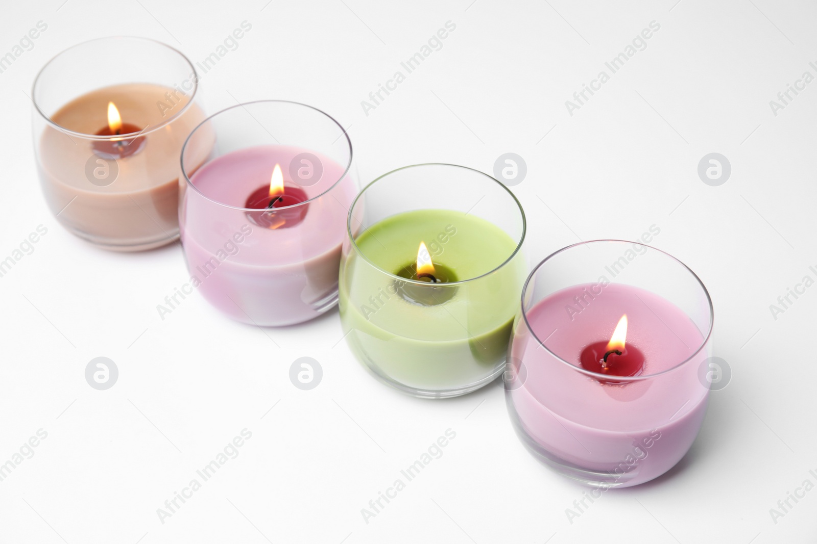 Photo of Color wax candles in glass holders isolated on white