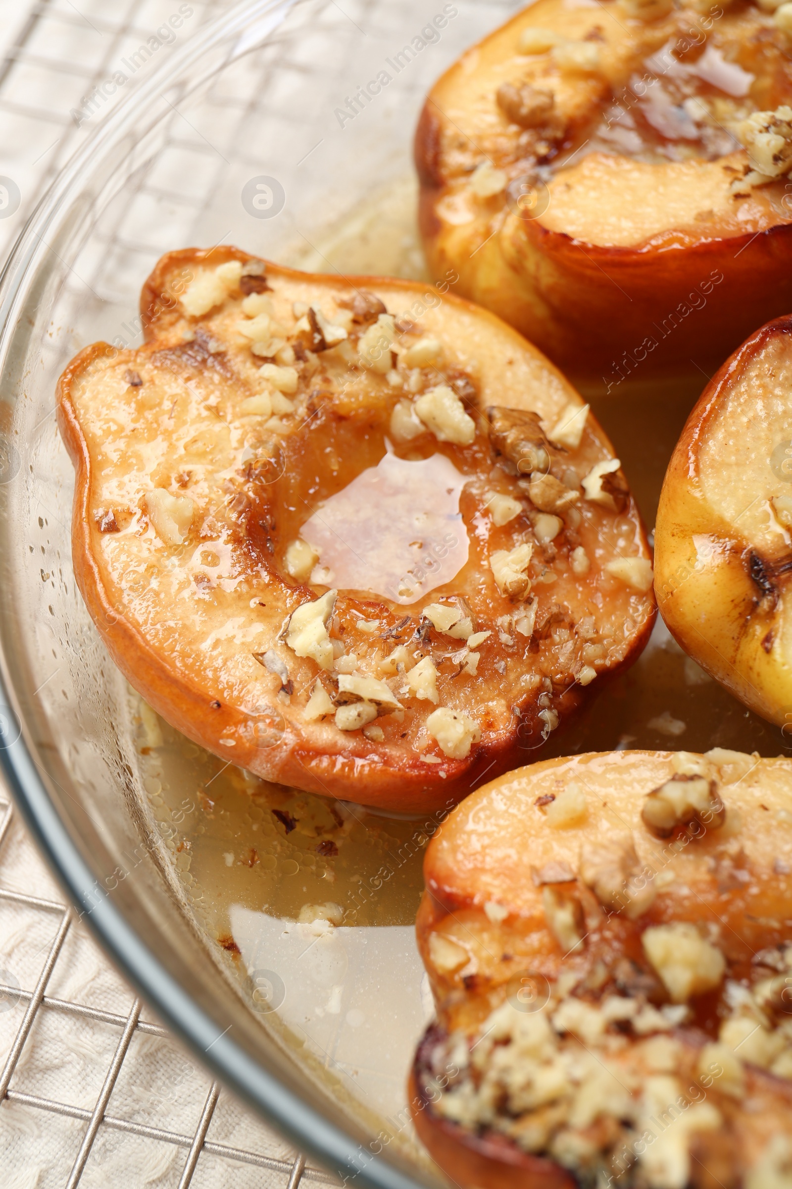 Photo of Delicious baked quinces with nuts and honey in bowl on table, closeup