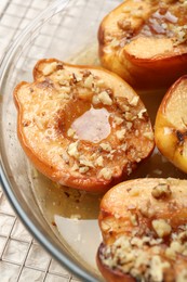 Photo of Delicious baked quinces with nuts and honey in bowl on table, closeup