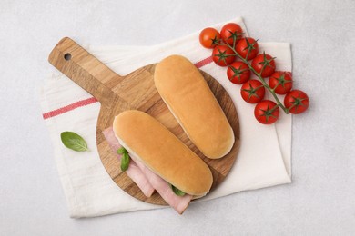 Photo of Delicious sandwich with ham, basil and products on light grey table, flat lay