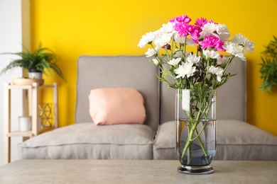 Photo of Beautiful bouquet of Chrysanthemum flowers on grey table indoors, space for text. Interior design