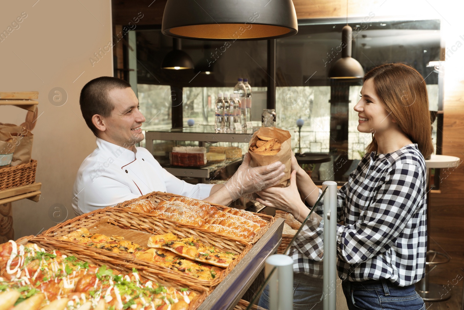 Photo of Woman buying tasty pastry in bakery shop