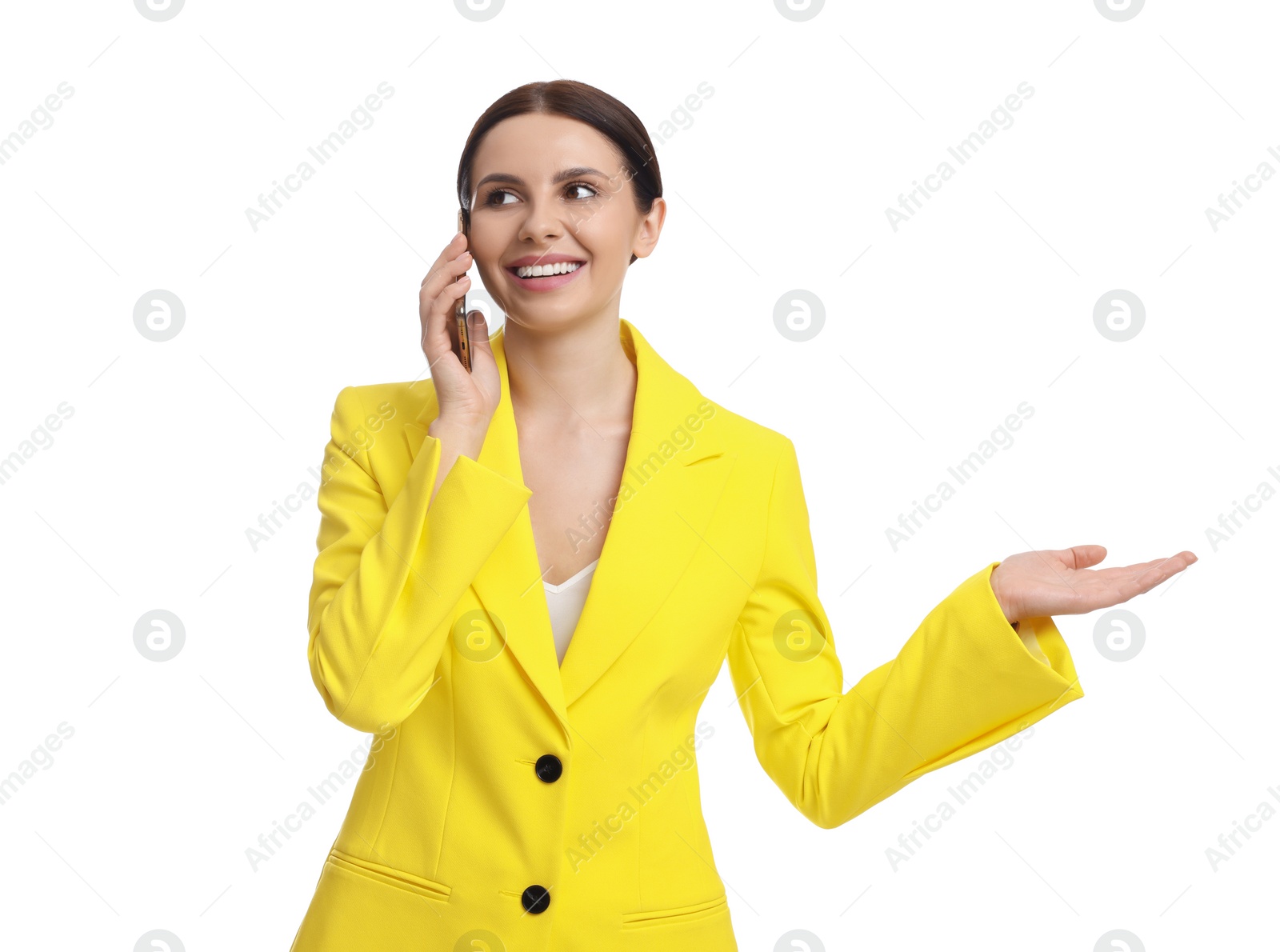 Photo of Beautiful businesswoman in yellow suit talking on smartphone against white background