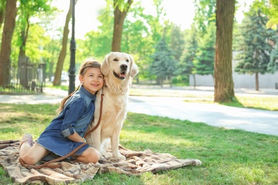 Photo of Cute little child with his pet in green park