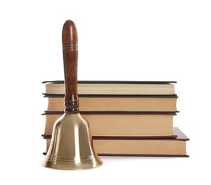 Golden school bell with wooden handle and stack of books on white background