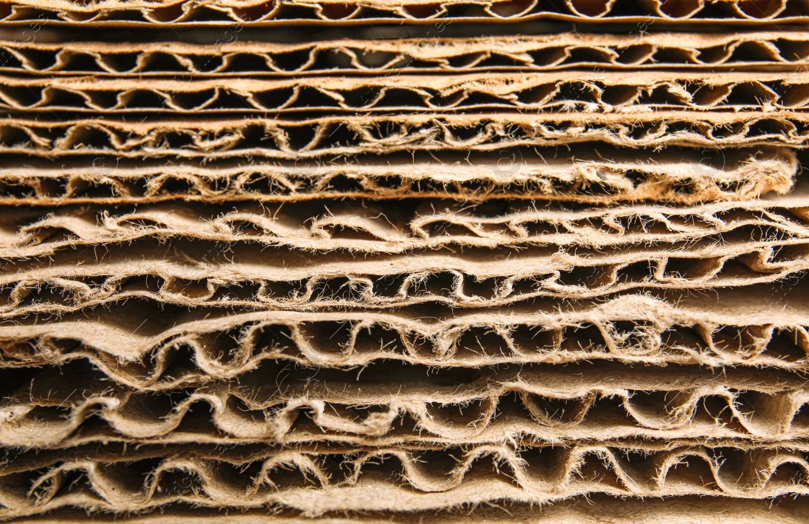 Photo of Sheets of brown corrugated cardboard as background, closeup