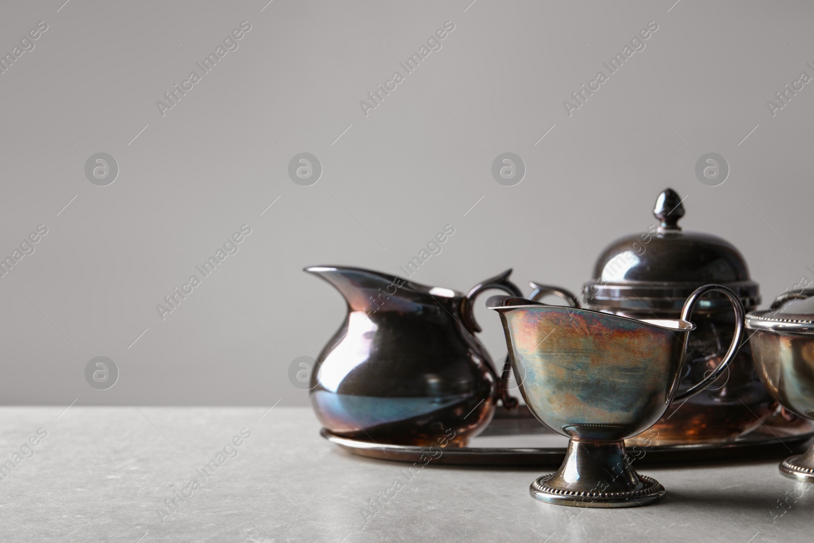 Photo of Beautiful tea set on grey textured table, space for text