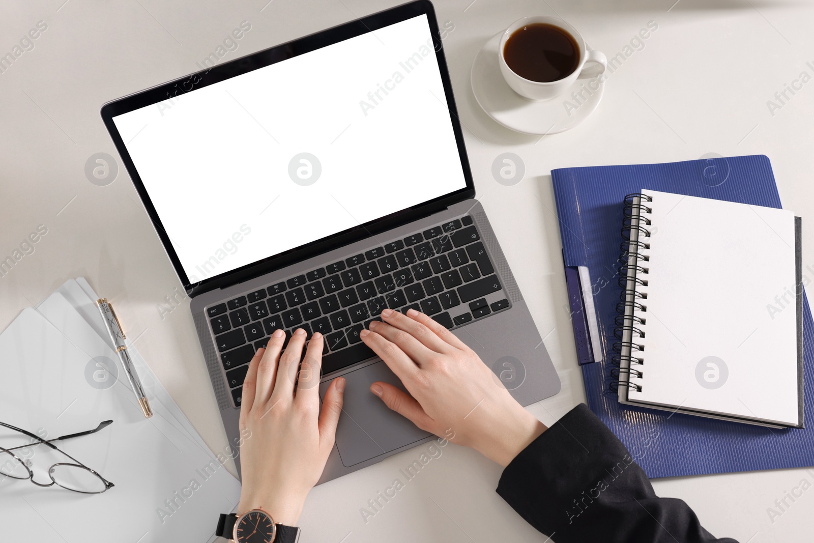 Photo of Woman working with laptop at white desk, top view