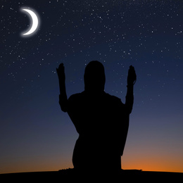 Silhouette of Muslim woman praying at night. Holy month of Ramadan