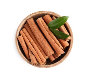 Cinnamon sticks and green leaves in bowl isolated on white, top view