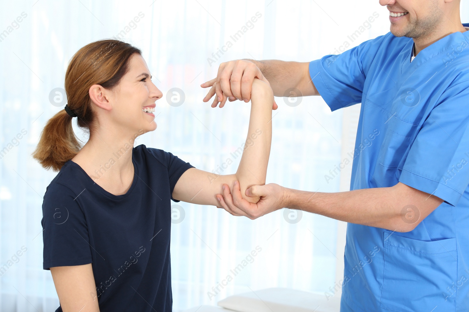 Photo of Physiotherapist working with patient in clinic. Rehabilitation therapy