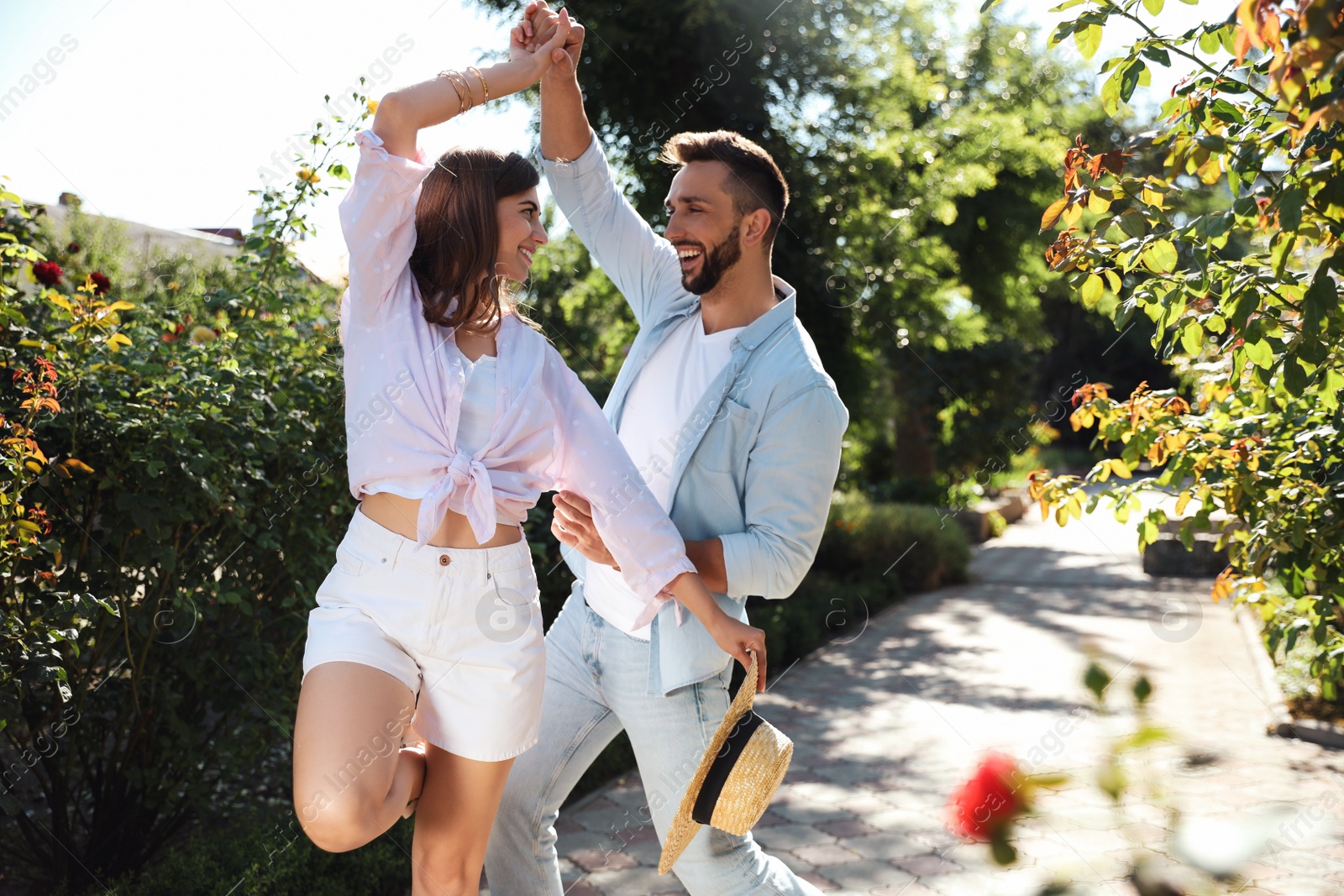 Photo of Lovely young couple dancing together in park on sunny day