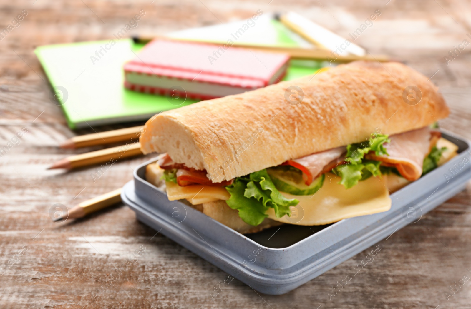 Photo of Lunch box with tasty food on wooden background