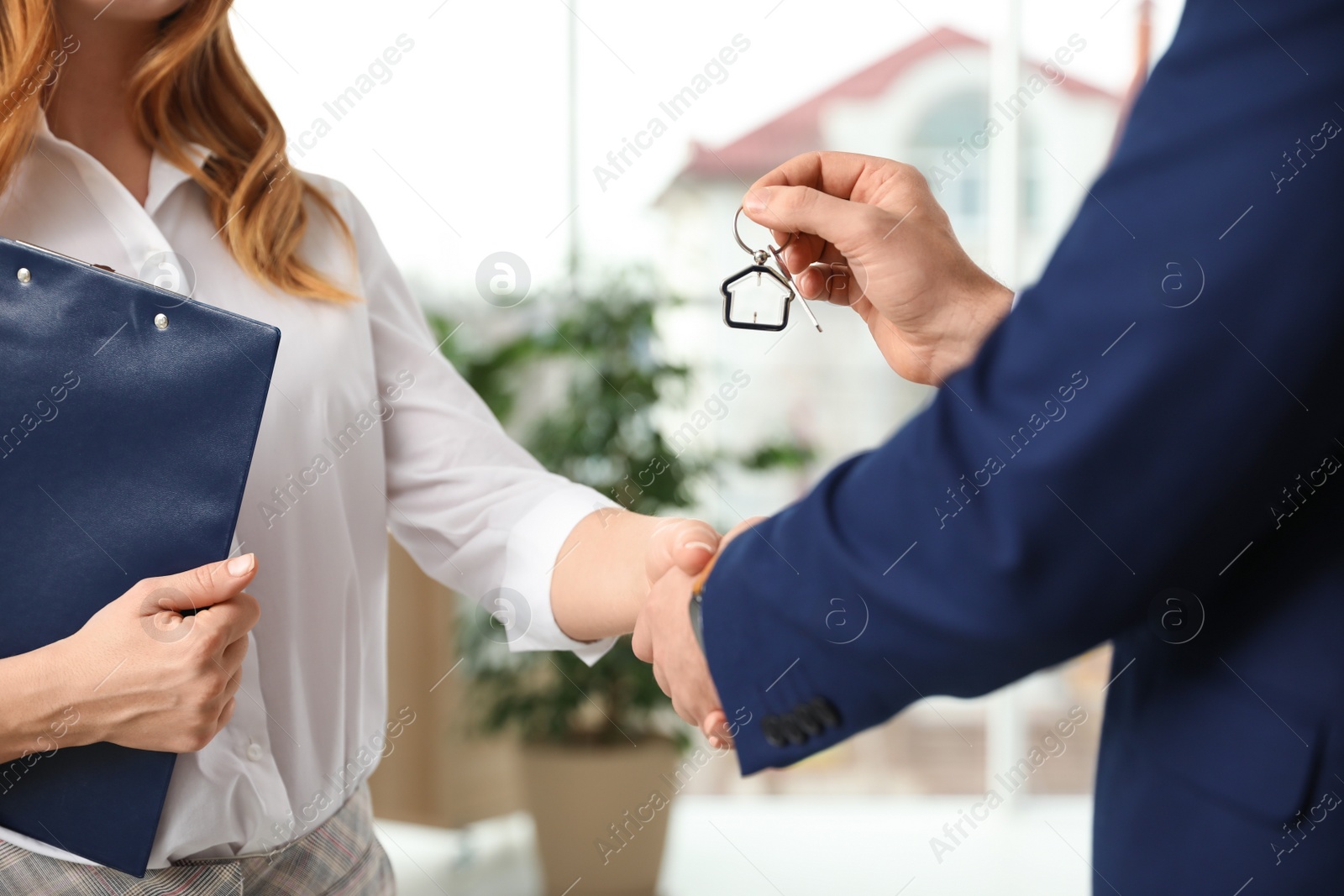 Photo of Real estate agent shaking hands with client in office, closeup