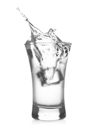 Ice cube falling into shot glass of vodka on white background