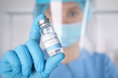 Photo of Doctor with coronavirus vaccine in laboratory, focus on hand