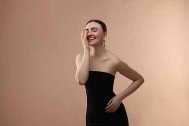 Photo of Portrait of beautiful young woman on beige background