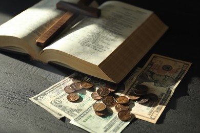 Photo of Donate and give concept. Coins, dollar banknotes, cross and Bible on dark table, closeup