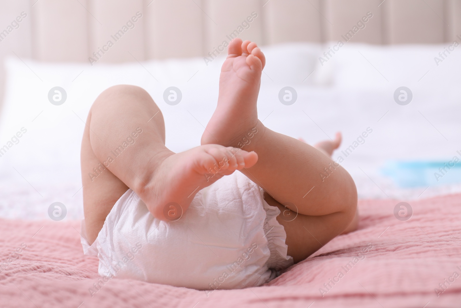 Photo of Little baby in diaper on bed, closeup