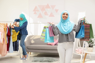 Photo of Muslim woman with shopping bags in modern shop
