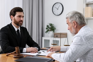 Photo of Senior man having meeting with lawyer in office