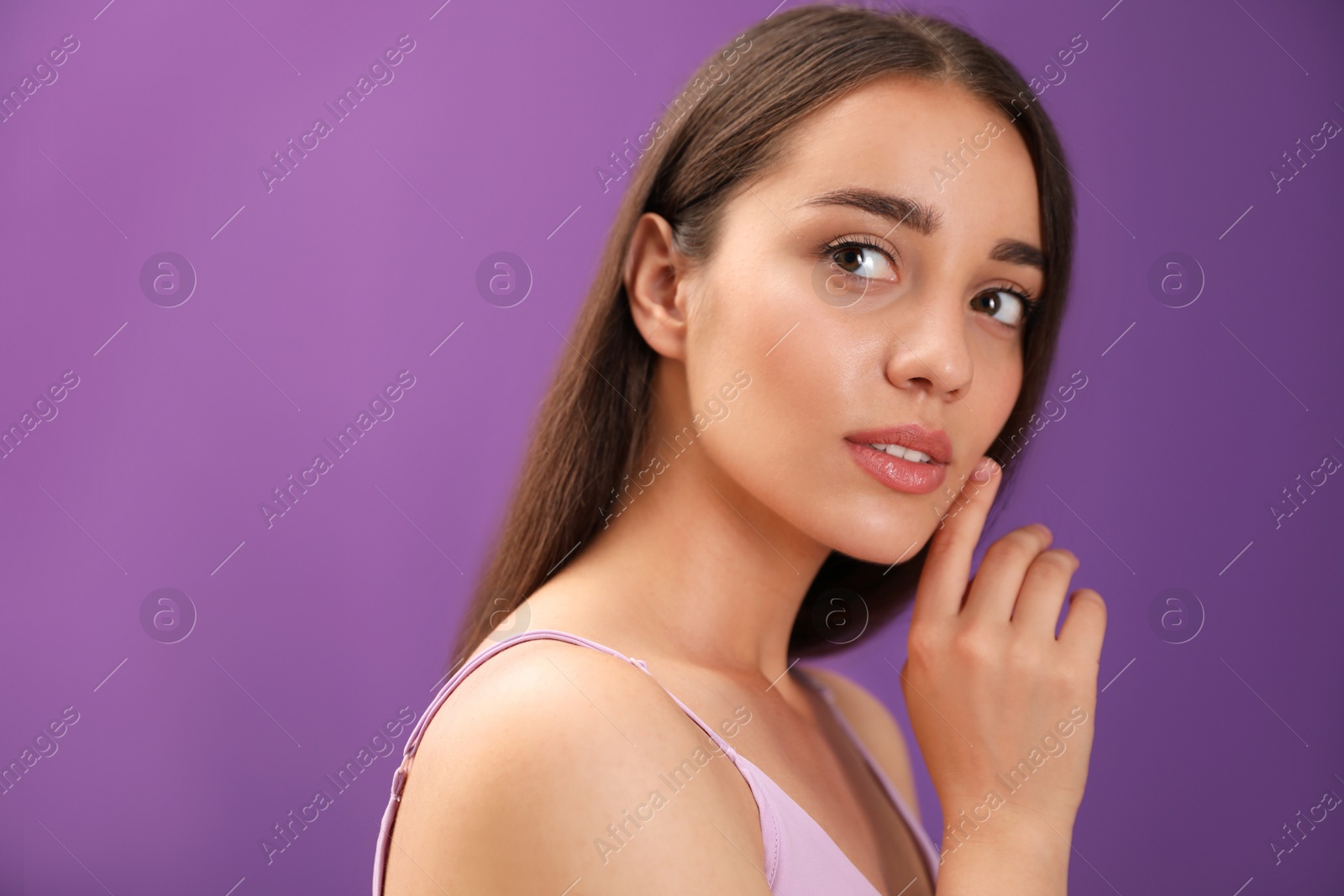 Photo of Portrait of beautiful young woman on purple background