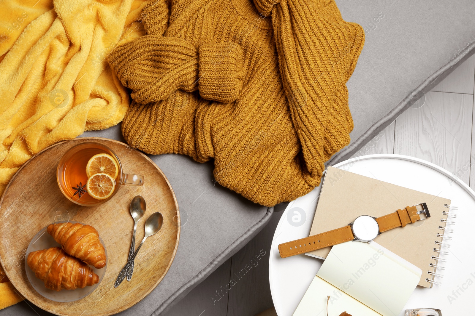 Photo of Warm knitted sweater on sofa at home, flat lay