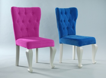 Photo of Stylish chairs on light grey background. Element of interior design