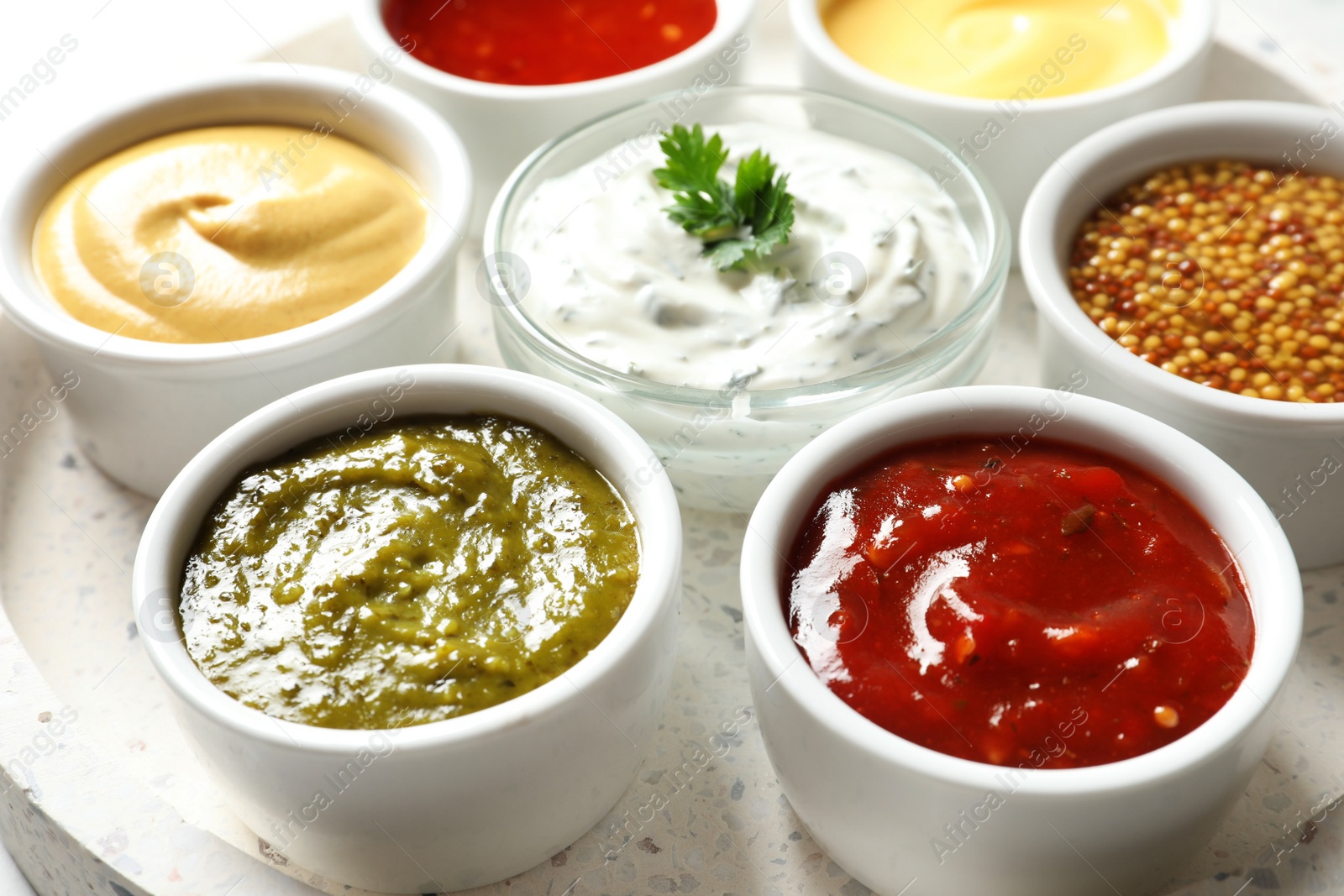 Photo of Set of different delicious sauces on tray, closeup